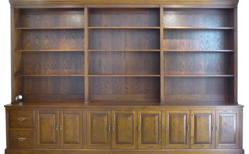 built-in traditional bookcase made to fit with drawers and routered cupboards in american oak